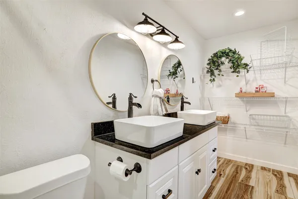 a bathroom with a sink a toilet and a mirror