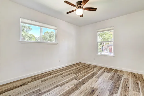 a view of empty room with window and ceiling fan