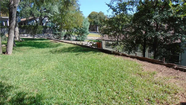 a view of a backyard with large trees