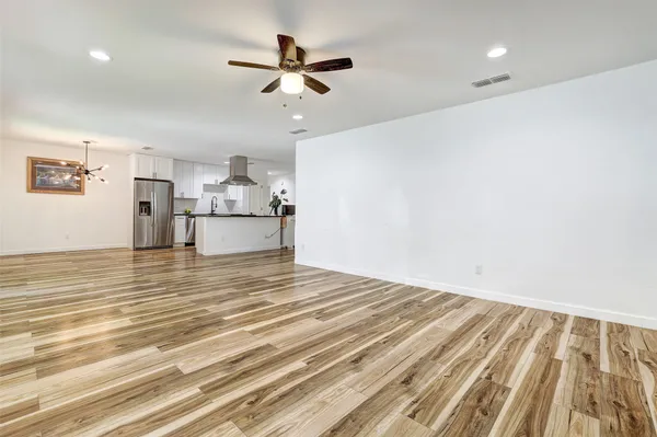 a view of empty room with wooden floor and window