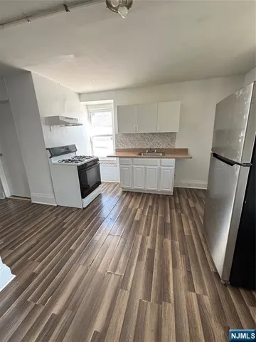 a kitchen with a refrigerator and a stove top oven