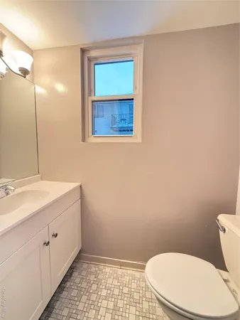 a bathroom with a toilet sink and mirror