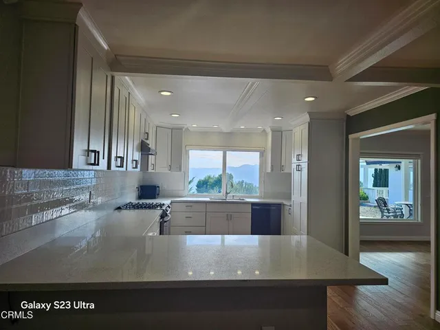 a view of a room with kitchen island a sink and wooden floor