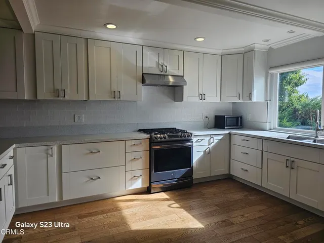 a kitchen with stainless steel appliances granite countertop a stove a sink and a refrigerator