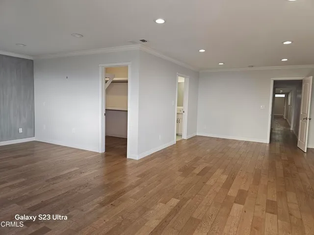 a view of empty room with wooden floor
