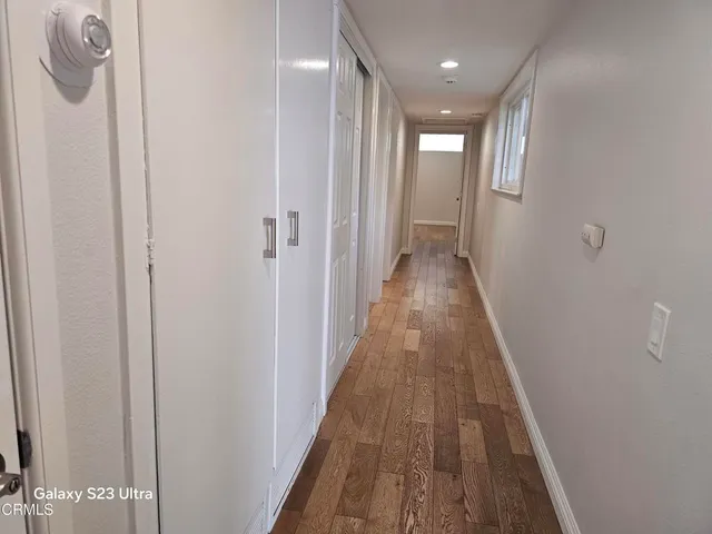 a view of a hallway with wooden floor