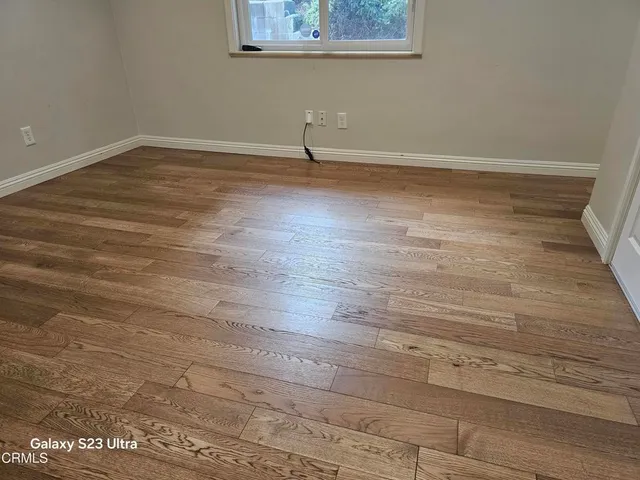 a view of a room with wooden floor and a window