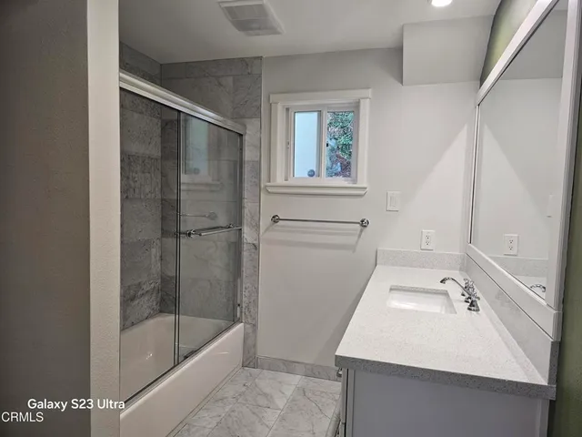 a bathroom with a sink a mirror and a bathtub