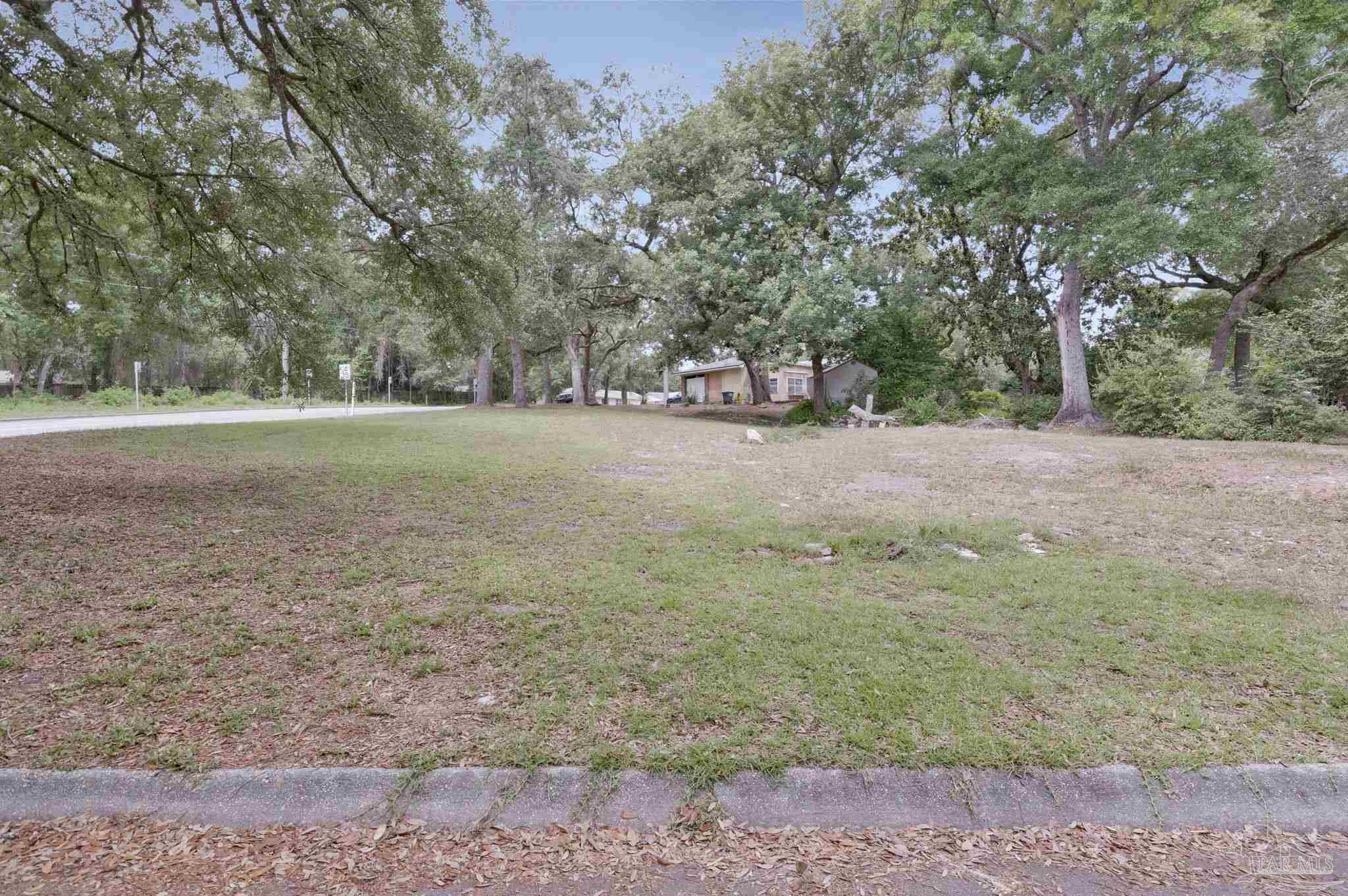 4891 Creighton Road Pensacola, FL 32504 - Photo 2 of 16 a view of a field with trees in the background