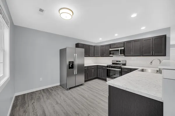 a kitchen with granite countertop stainless steel appliances and refrigerator