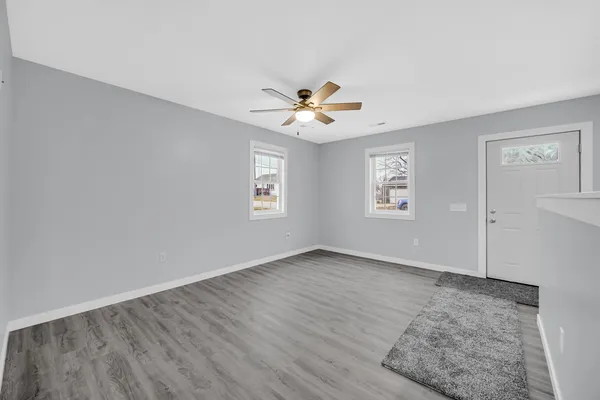 an empty room with a window and a fan
