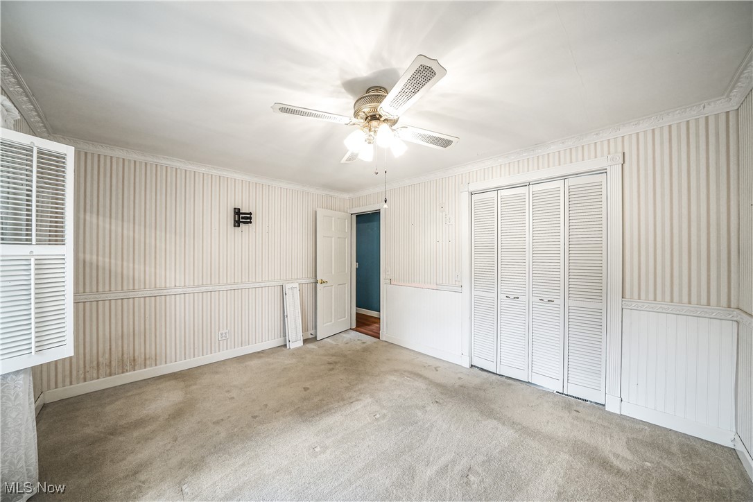 2822 Selkirk Bush Road Warren, OH 44481 - Photo 16 of 50 Unfurnished bedroom with carpet flooring, ornamental molding, a closet, and ceiling fan