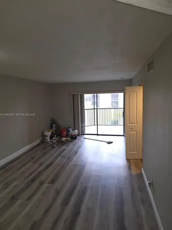 a view of a room with wooden floor and window
