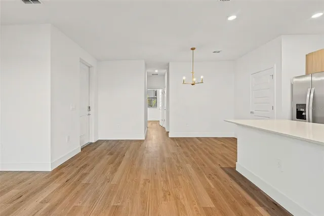 a large kitchen with granite countertop a white stove top oven and white cabinets
