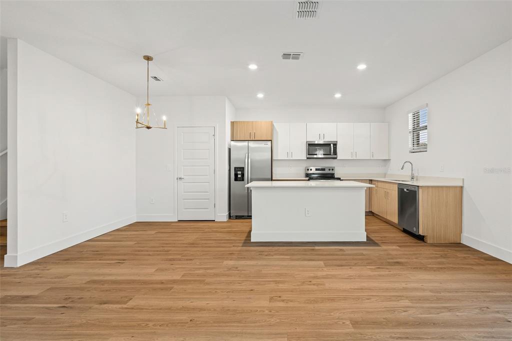 8025 Gulfstream Court Lakewood Ranch, FL 34202 - Photo 12 of 44 a large kitchen with granite countertop a white stove top oven and white cabinets