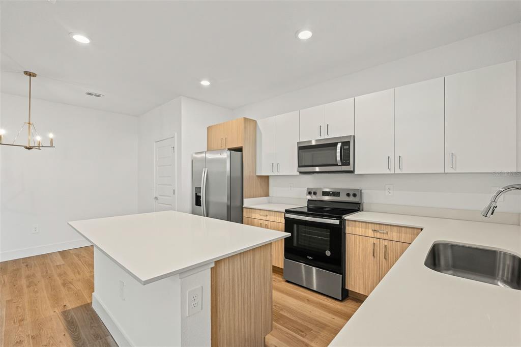 8025 Gulfstream Court Lakewood Ranch, FL 34202 - Photo 13 of 44 a kitchen with a sink a microwave a stove and refrigerator