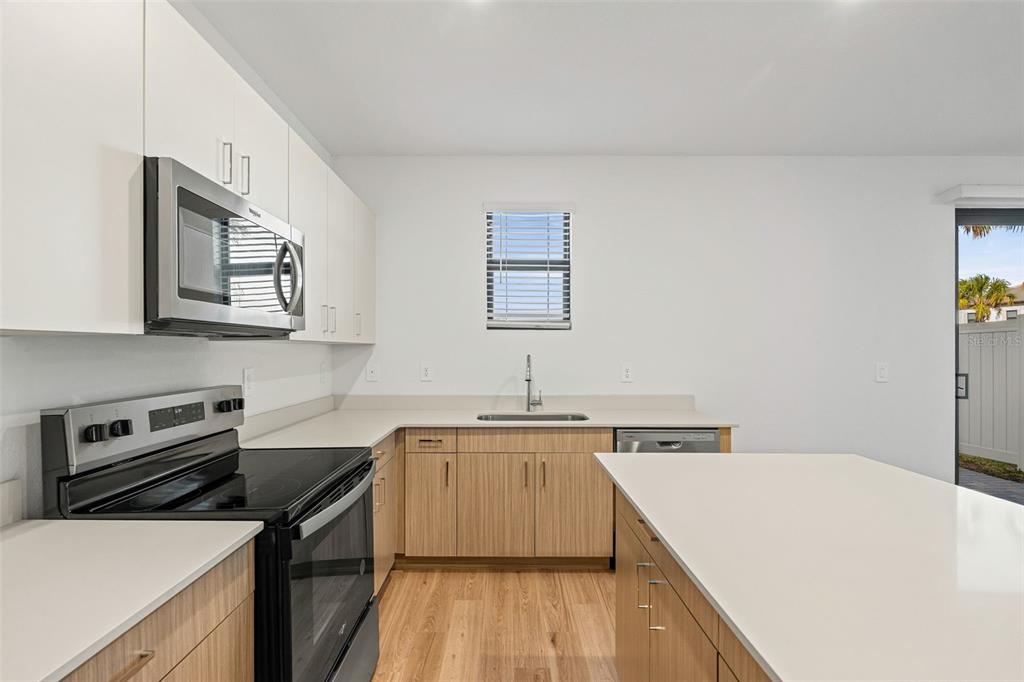 8025 Gulfstream Court Lakewood Ranch, FL 34202 - Photo 14 of 44 a kitchen with a sink a stove and cabinets