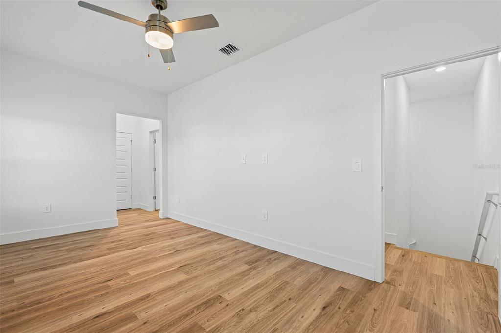 8025 Gulfstream Court Lakewood Ranch, FL 34202 - Photo 22 of 44 an empty room with wooden floor fan and windows