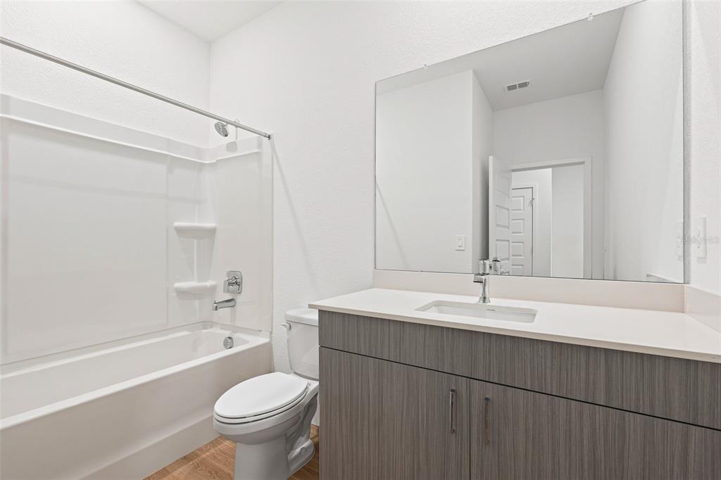 8025 Gulfstream Court Lakewood Ranch, FL 34202 - Photo 37 of 44 a bathroom with a sink a toilet and a large mirror