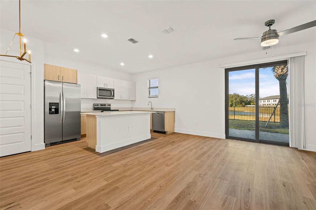 8025 Gulfstream Court Lakewood Ranch, FL 34202 - Photo 6 of 44 a view of kitchen with stainless steel appliances wooden floor and large window