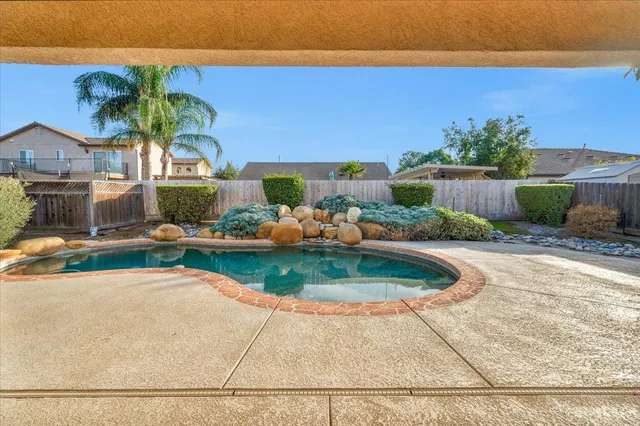 a large room with chandelier fan and windows