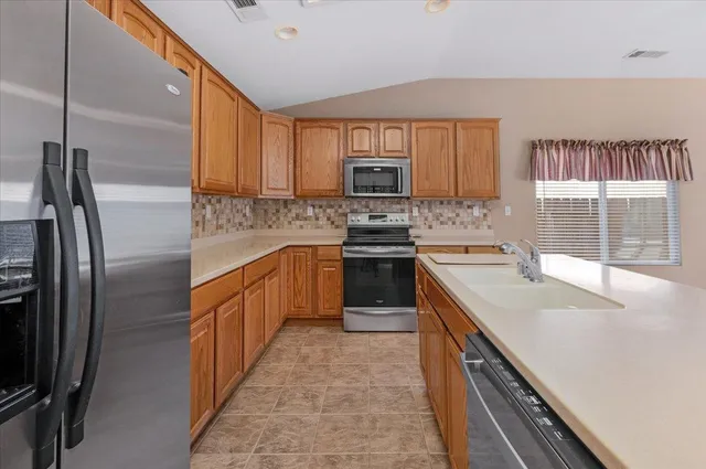 a view of a house with a yard and large tree
