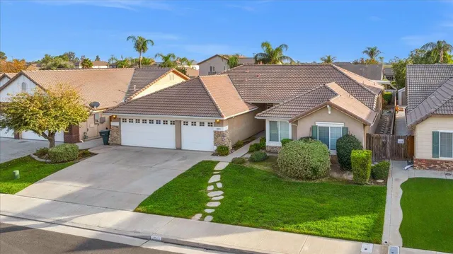 a kitchen with stainless steel appliances granite countertop a sink a stove a refrigerator cabinets and a window