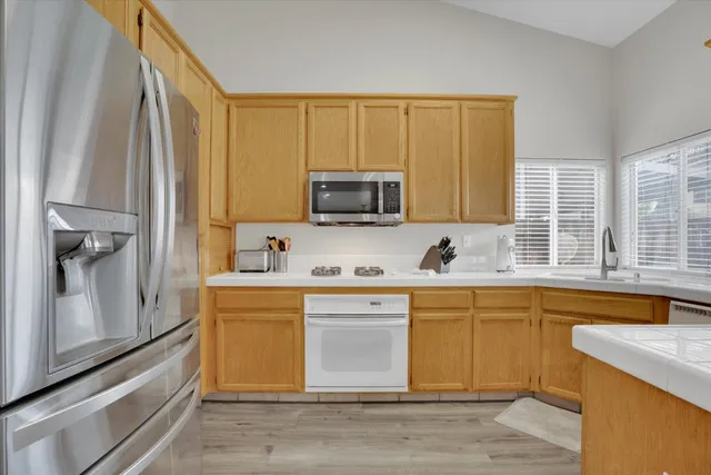 a kitchen with stainless steel appliances granite countertop a stove a sink and a microwave