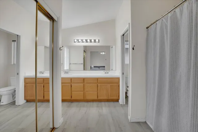 a bathroom with a granite countertop sink mirror and a toilet