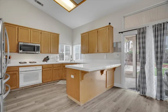 a kitchen with stainless steel appliances granite countertop a stove a sink and a refrigerator
