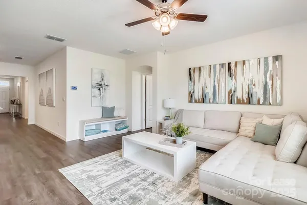 a living room with furniture and a wooden floor