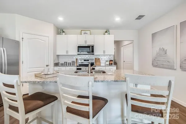 a kitchen with kitchen island cabinets and white appliances