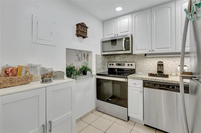 a kitchen with white cabinets and white appliances