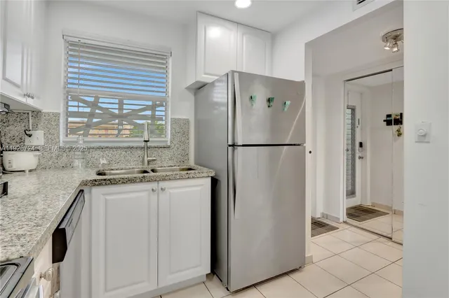 a kitchen with stainless steel appliances granite countertop a refrigerator a stove and a sink