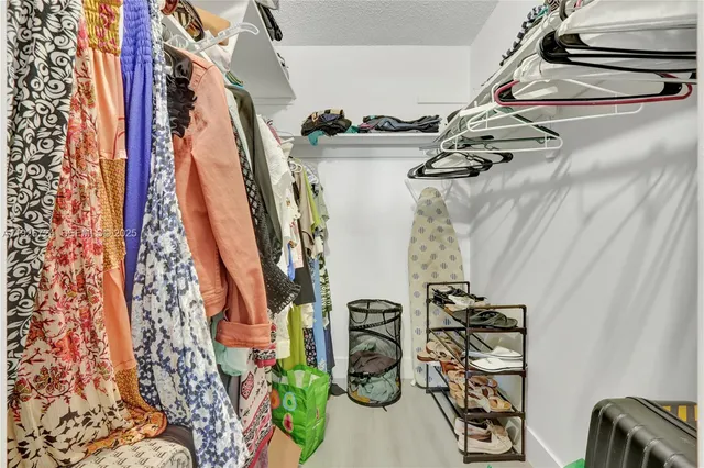a view of walk in closet with clothes