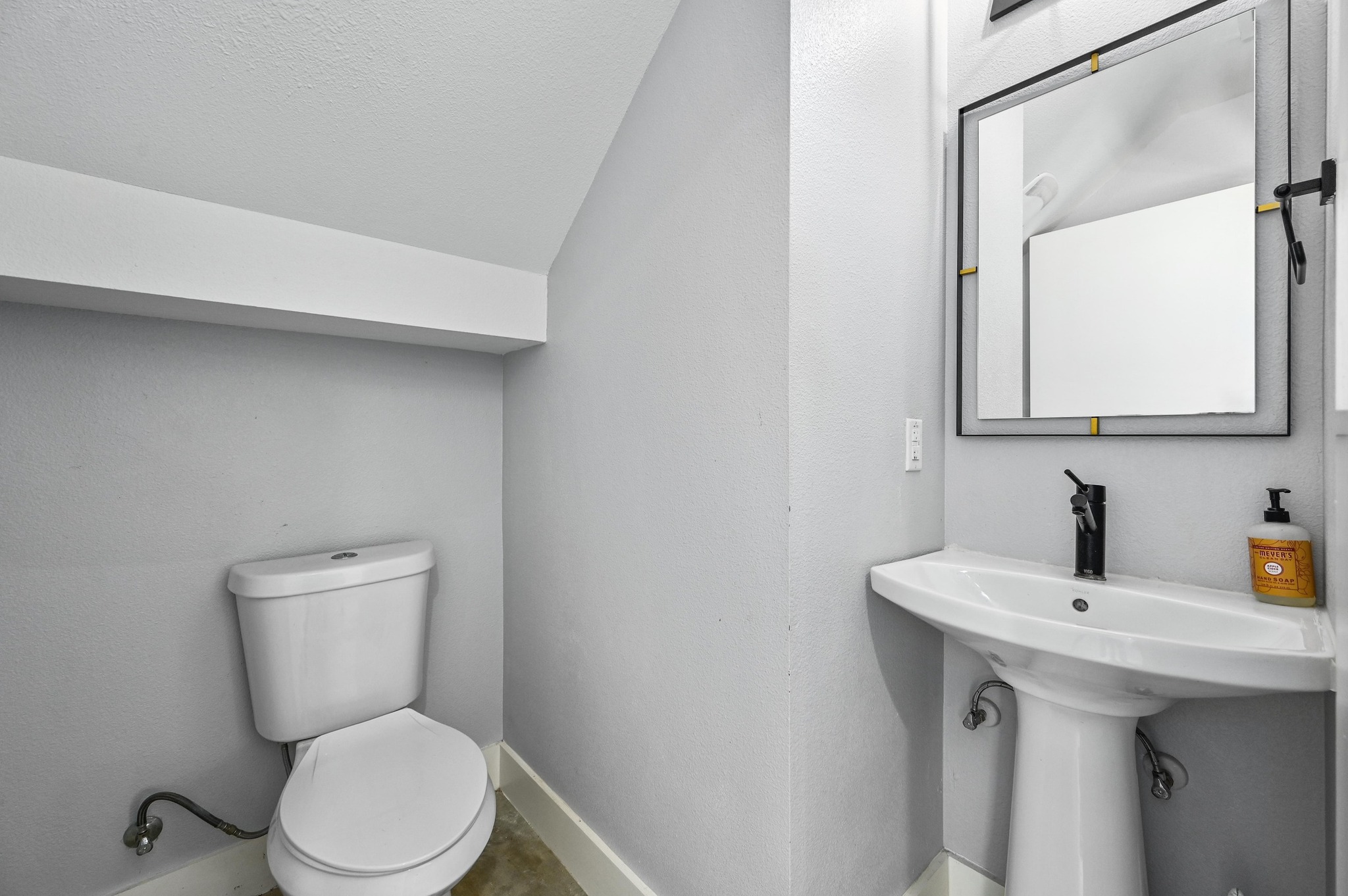 1210 Luna Street, Unit 2 Austin, TX 78721 - Photo 10 of 17 a bathroom with a toilet sink and mirror