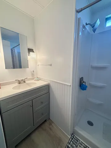 a bathroom with a shower sink and mirror