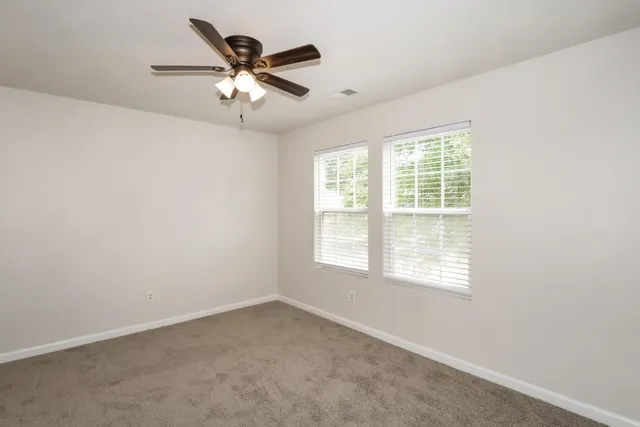 an empty room with a window and a fan