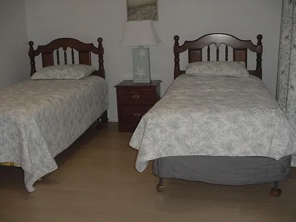 a bedroom with bed and a two windows