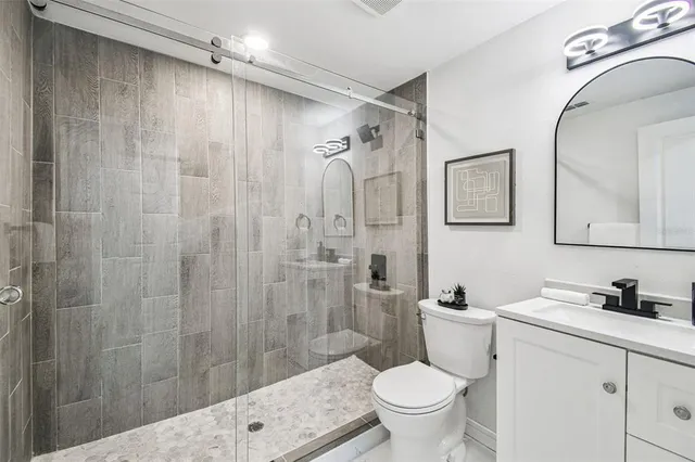 a bathroom with a granite countertop sink toilet and shower