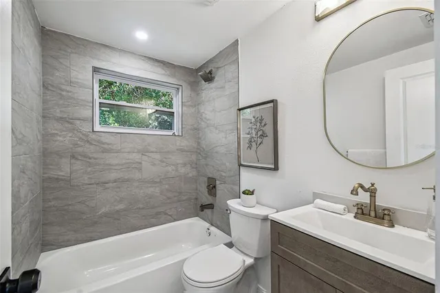 a bathroom with a toilet a sink a mirror and a bathtub