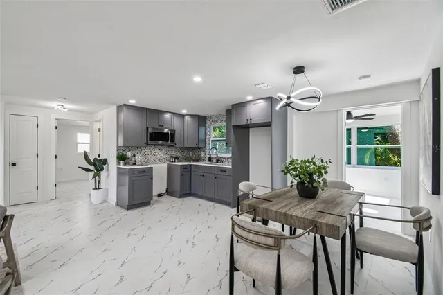 a kitchen with granite countertop stainless steel appliances a sink and a refrigerator