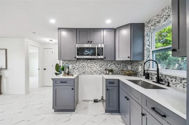 a kitchen with kitchen island granite countertop a sink window and cabinets