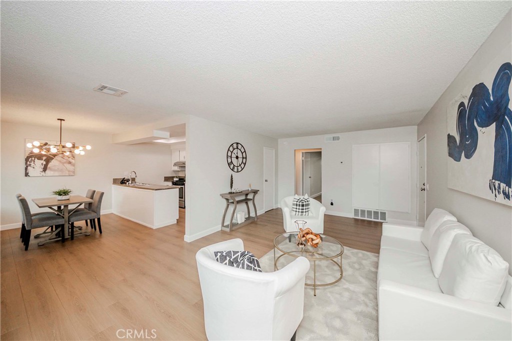 1525 Walnut Leaf Drive, Unit 211 Walnut, CA 91789 - Photo 2 of 26 a living room with furniture and a chandelier