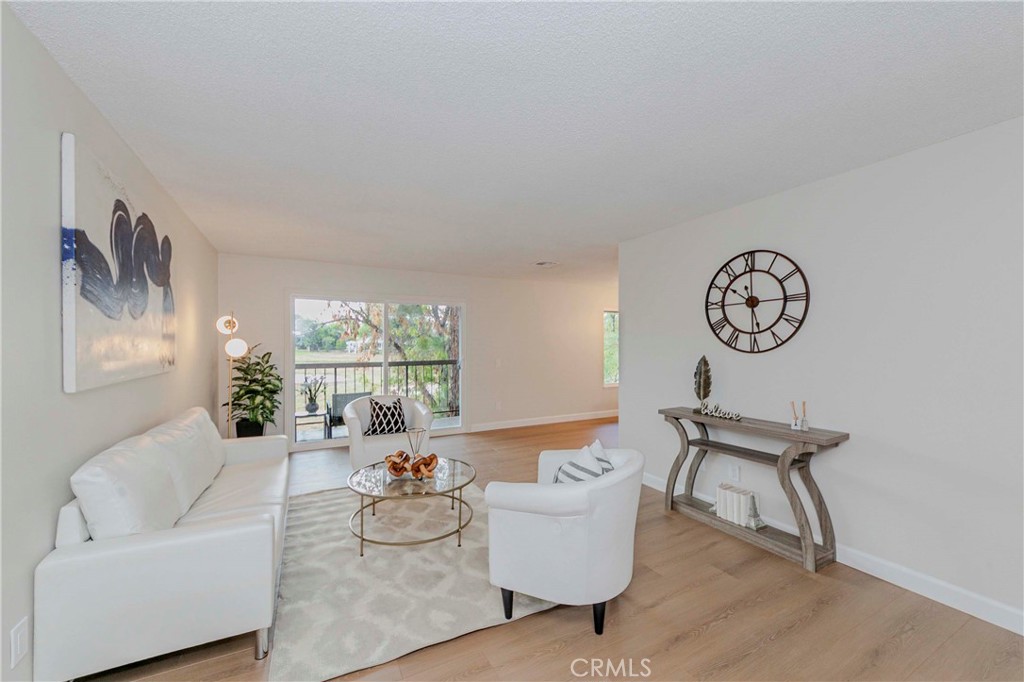 1525 Walnut Leaf Drive, Unit 211 Walnut, CA 91789 - Photo 4 of 26 a living room with furniture a large window and a clock