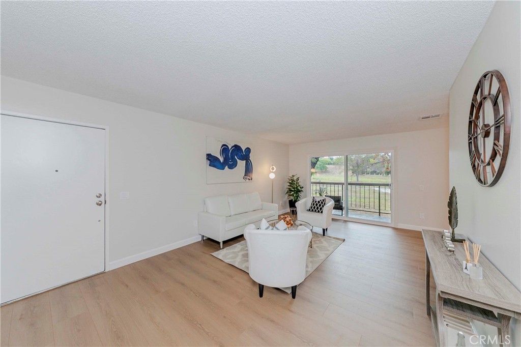 1525 Walnut Leaf Drive, Unit 211 Walnut, CA 91789 - Photo 5 of 26 a living room with furniture and a large window