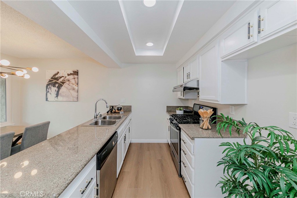 1525 Walnut Leaf Drive, Unit 211 Walnut, CA 91789 - Photo 10 of 26 a kitchen with granite countertop a stove a sink and a refrigerator