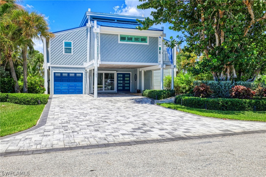 1021 Sand Castle Road Sanibel, FL 33957 - Photo 2 of 49 a front view of a house with a yard and potted plants