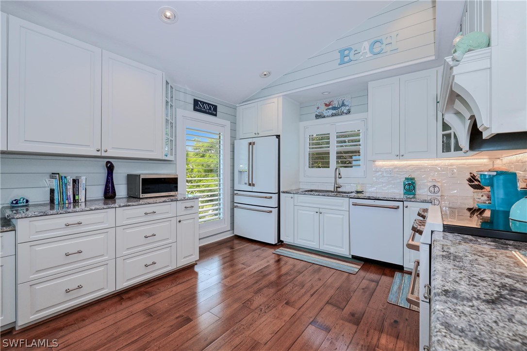 1021 Sand Castle Road Sanibel, FL 33957 - Photo 22 of 49 a kitchen with stainless steel appliances sink stove top oven and cabinets