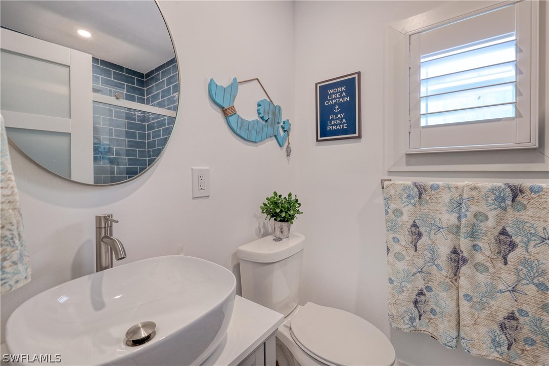 1021 Sand Castle Road Sanibel, FL 33957 - Photo 38 of 49 a bathroom with a sink a toilet and a mirror